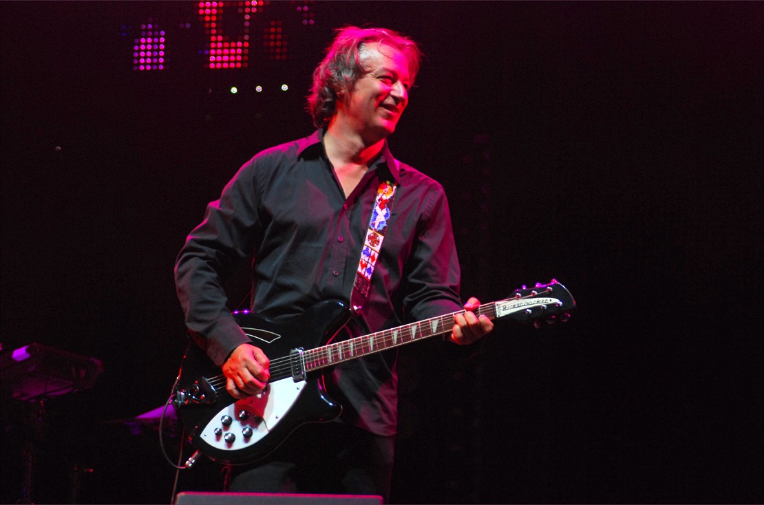Peter Buck playing guitar on stage