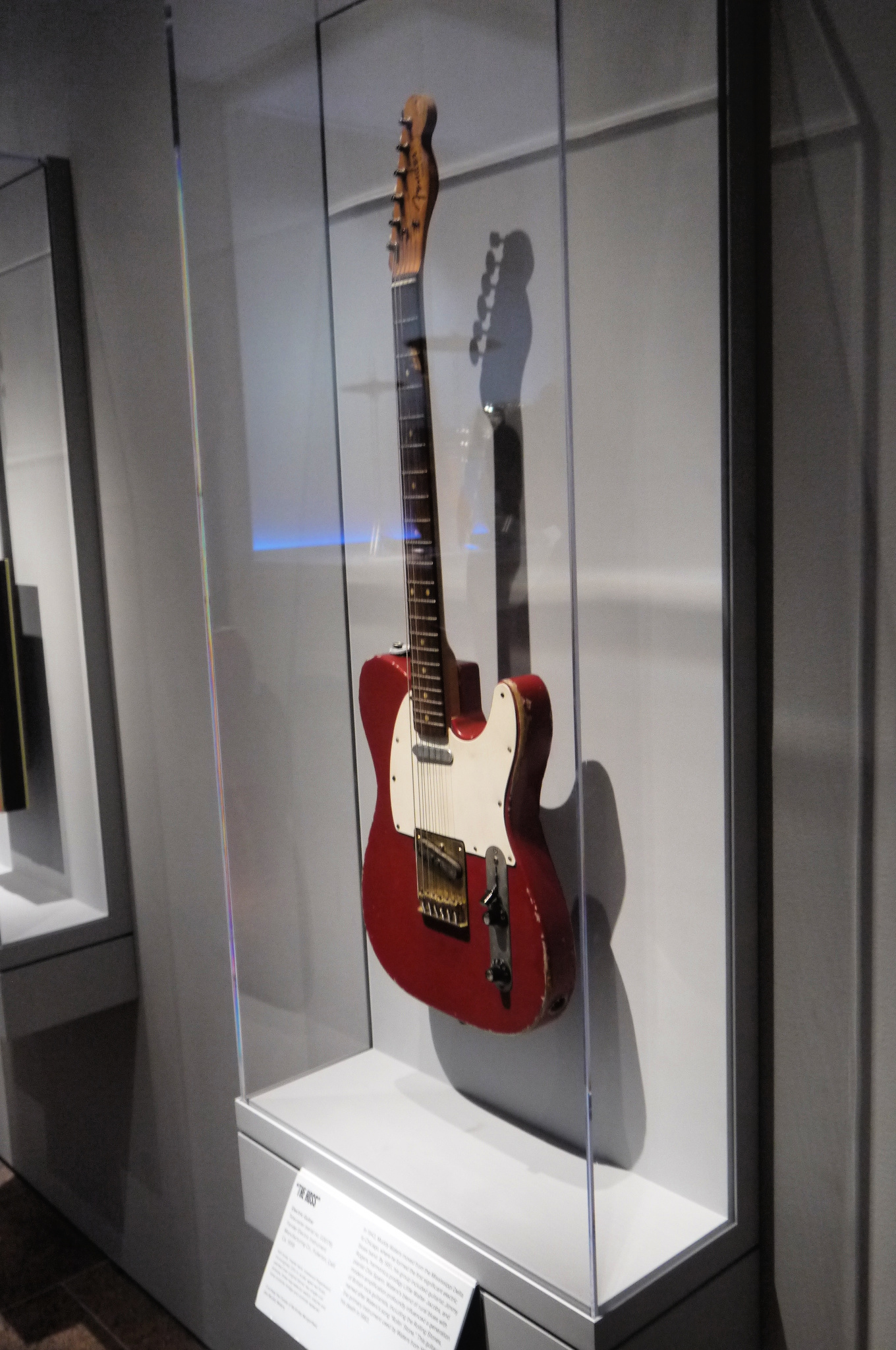 Muddy Waters' red Fender Telecaster known as "The Hoss" displayed upright in a glass case at the Metropolitan Museum of Art, 2019