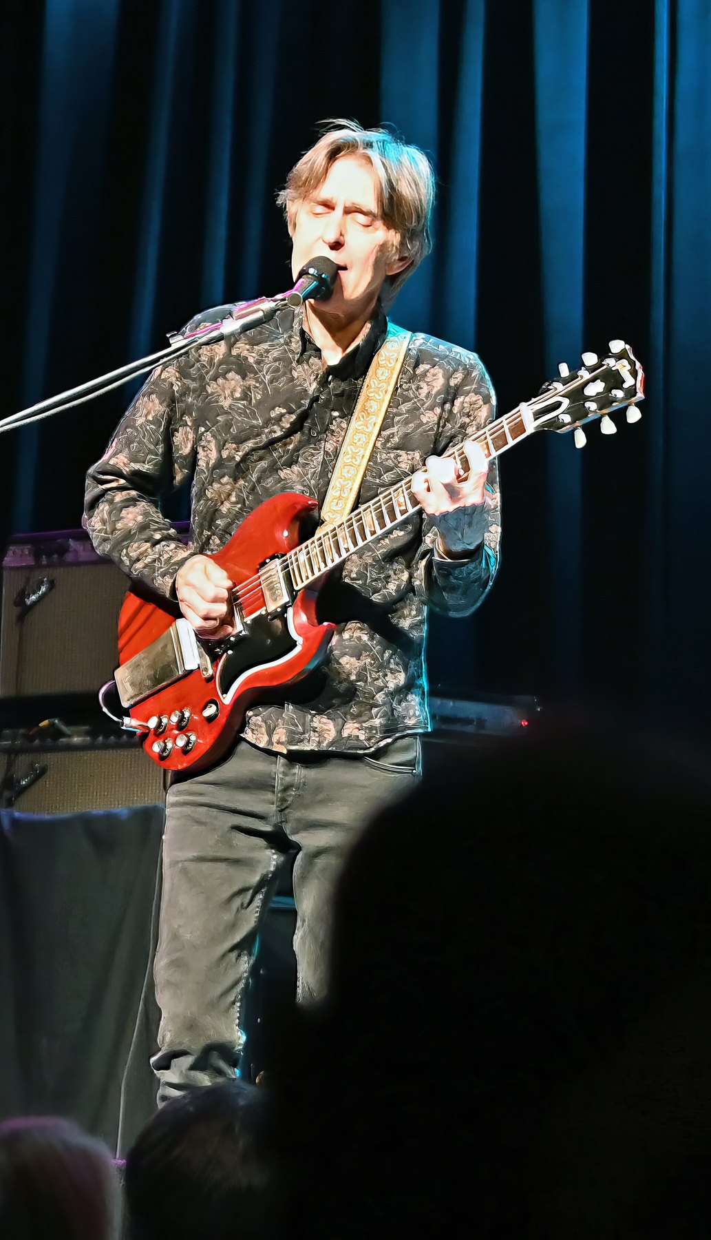 Eric Johnson singing and playing a cherry Gibson SG at Ponte Vedra Concert Hall in March 2023