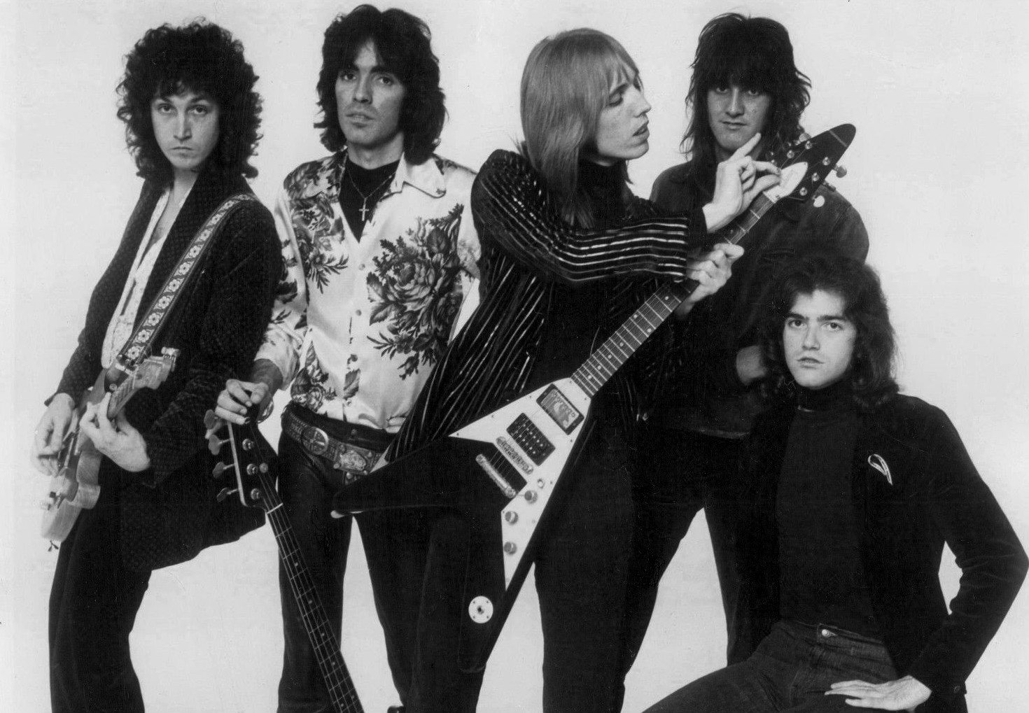 Black-and-white 1977 publicity photo of Tom Petty and the Heartbreakers, with Tom Petty holding a Flying V-style guitar
