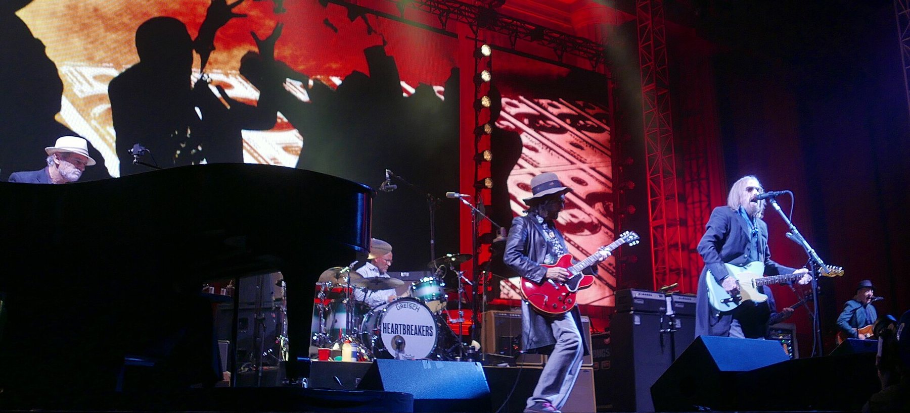 Tom Petty and the Heartbreakers performing on a red-lit stage in Berkeley, California, in August 2017