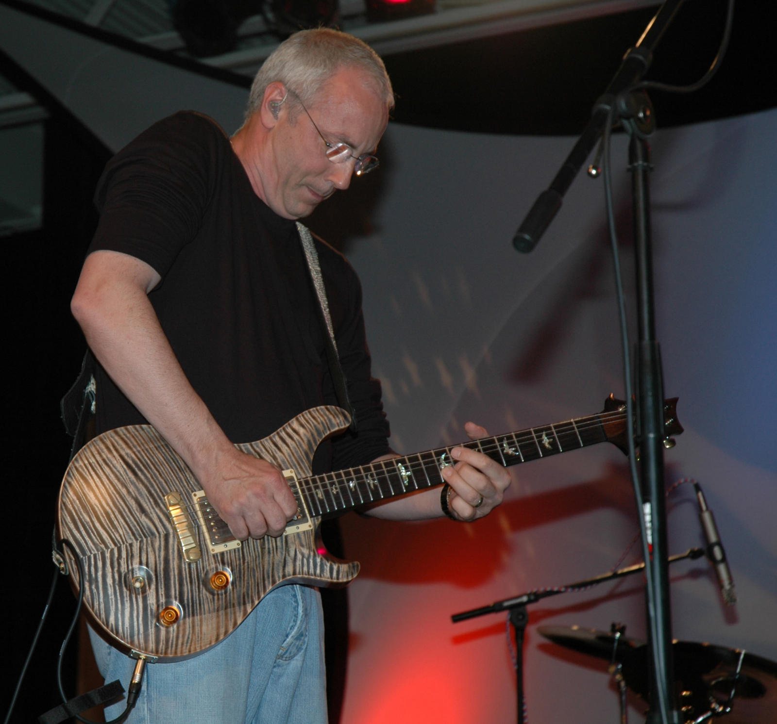 Paul Reed Smith playing one of his guitars on stage