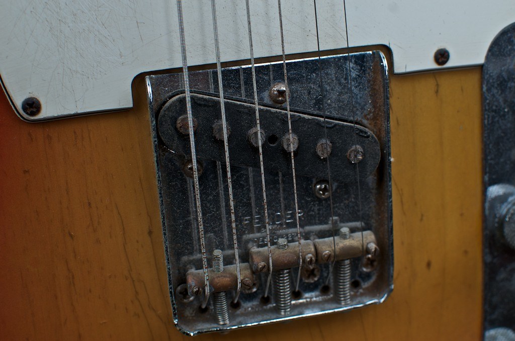 Close-up of a Telecaster bridge plate, three saddles and slanted bridge pickup