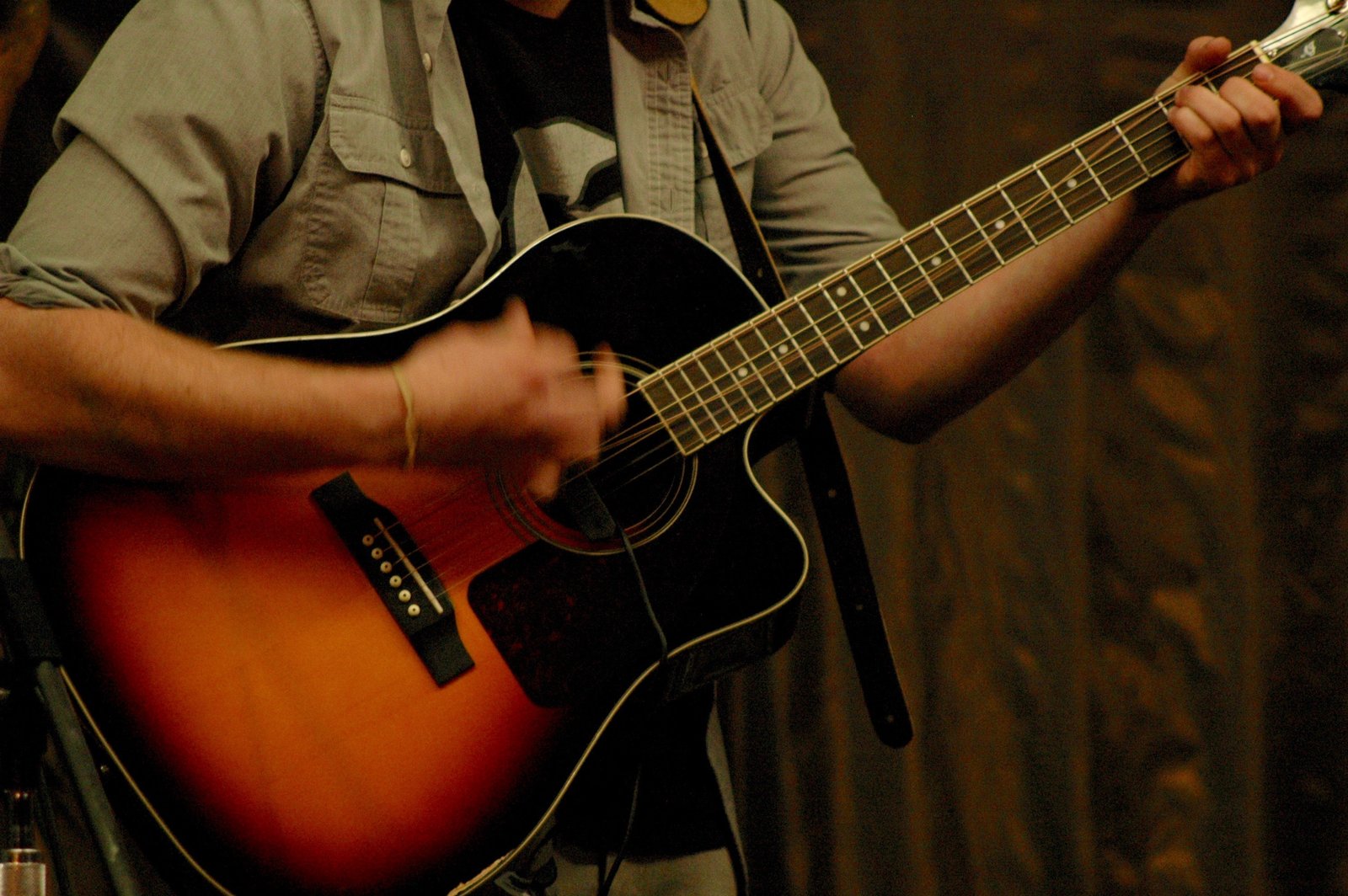 A snapped A string on an acoustic guitar. Most breaks start at a weak spot: an old string, corrosion, or a burr at the bridge or nut.